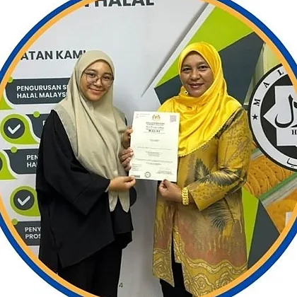 Two women from Restoran Nasi Ulam Kak Su holding a halal certificate