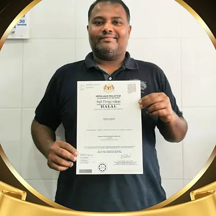 Encik Fais of Tea Kadai holding a halal certificate